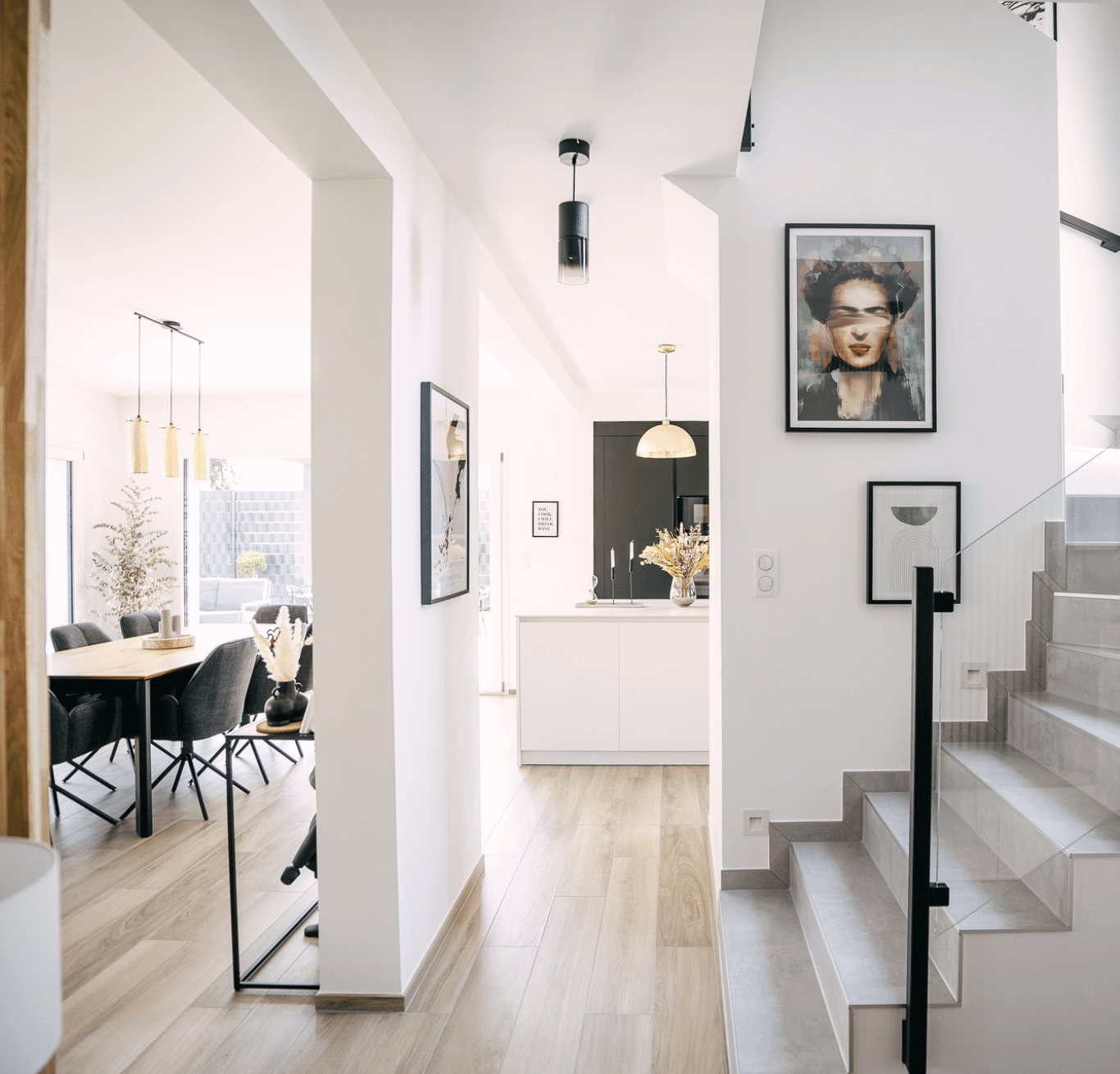 J’ai trouvé mon terrain, je cherche des idées de maisons. Intérieur lumineux et moderne d'une maison Stéphane Berger, avec cuisine ouverte, salle à manger élégante et escalier design, reflétant des espaces fonctionnels et esthétiques.