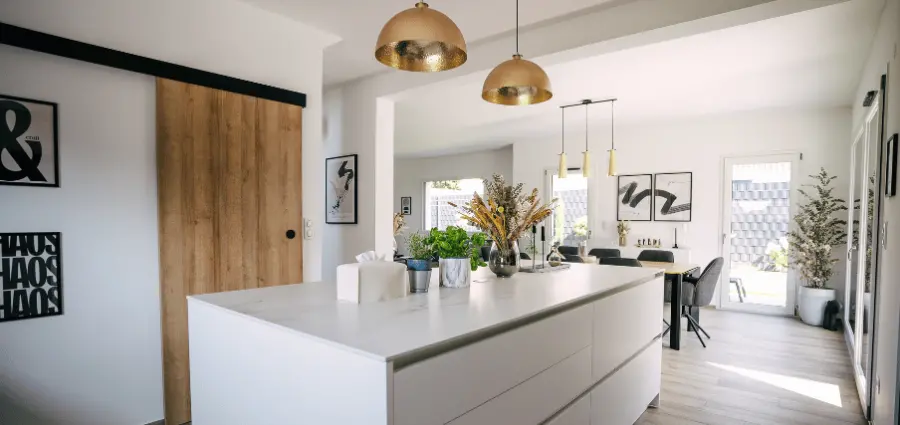 cuisine luùineuse avec ilot central vue sur la piece de vie et acces jardin