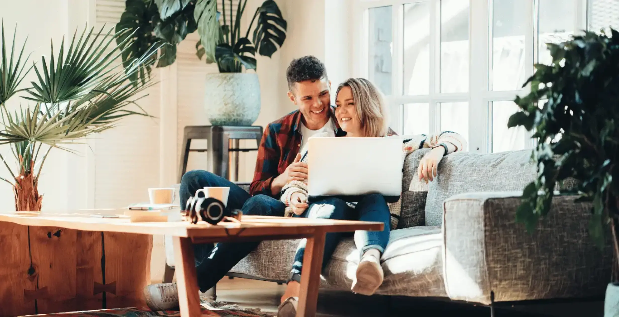 Un couple heureux consulte en ligne leur projet de maison individuelle en Alsace