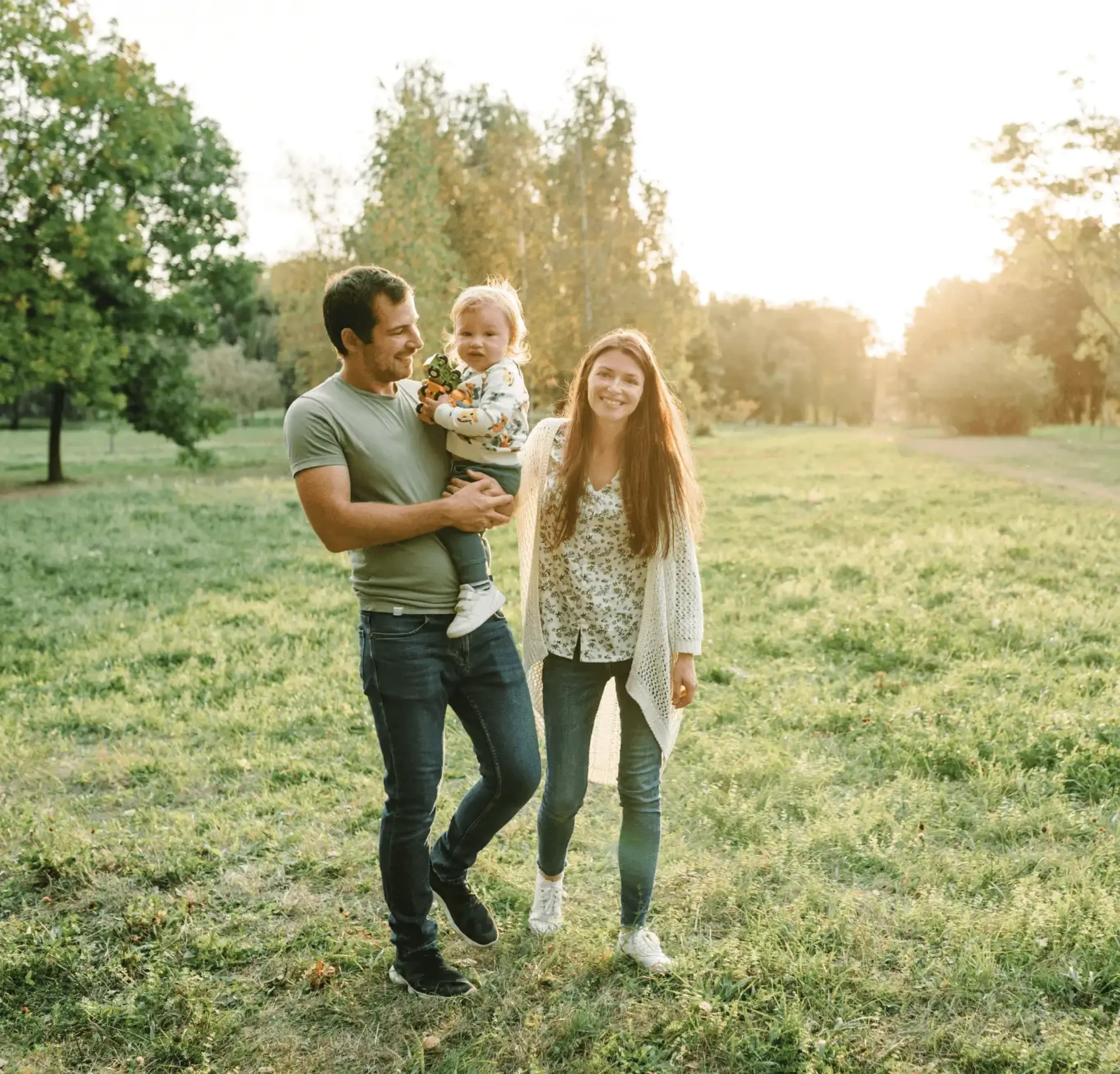 Jeune famille souriante en promenade, projetant la construction de leur maison en Alsace