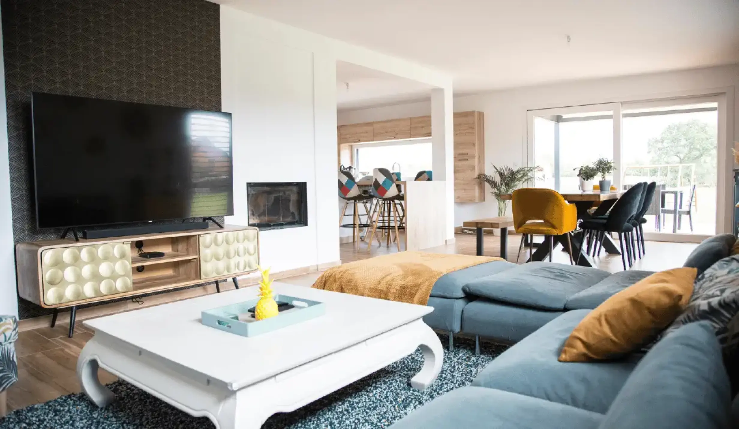 Salon spacieux avec canapé d’angle, décoration moderne et vue sur la cuisine ouverte.