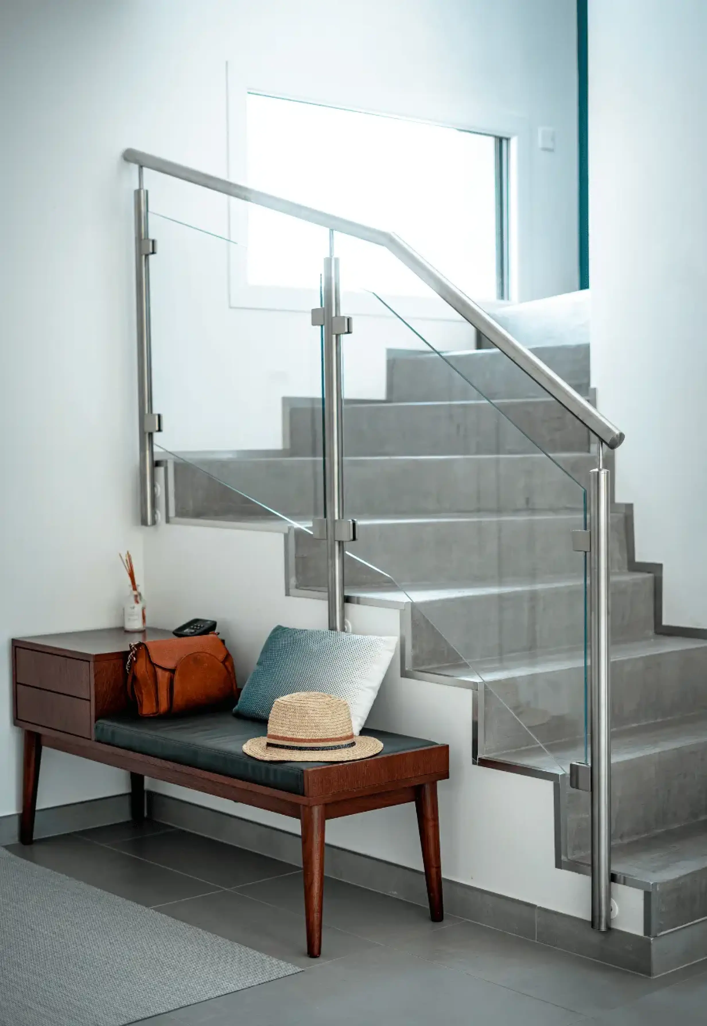 Escalier intérieur moderne avec rampe en verre et structure métallique, dans une maison design.