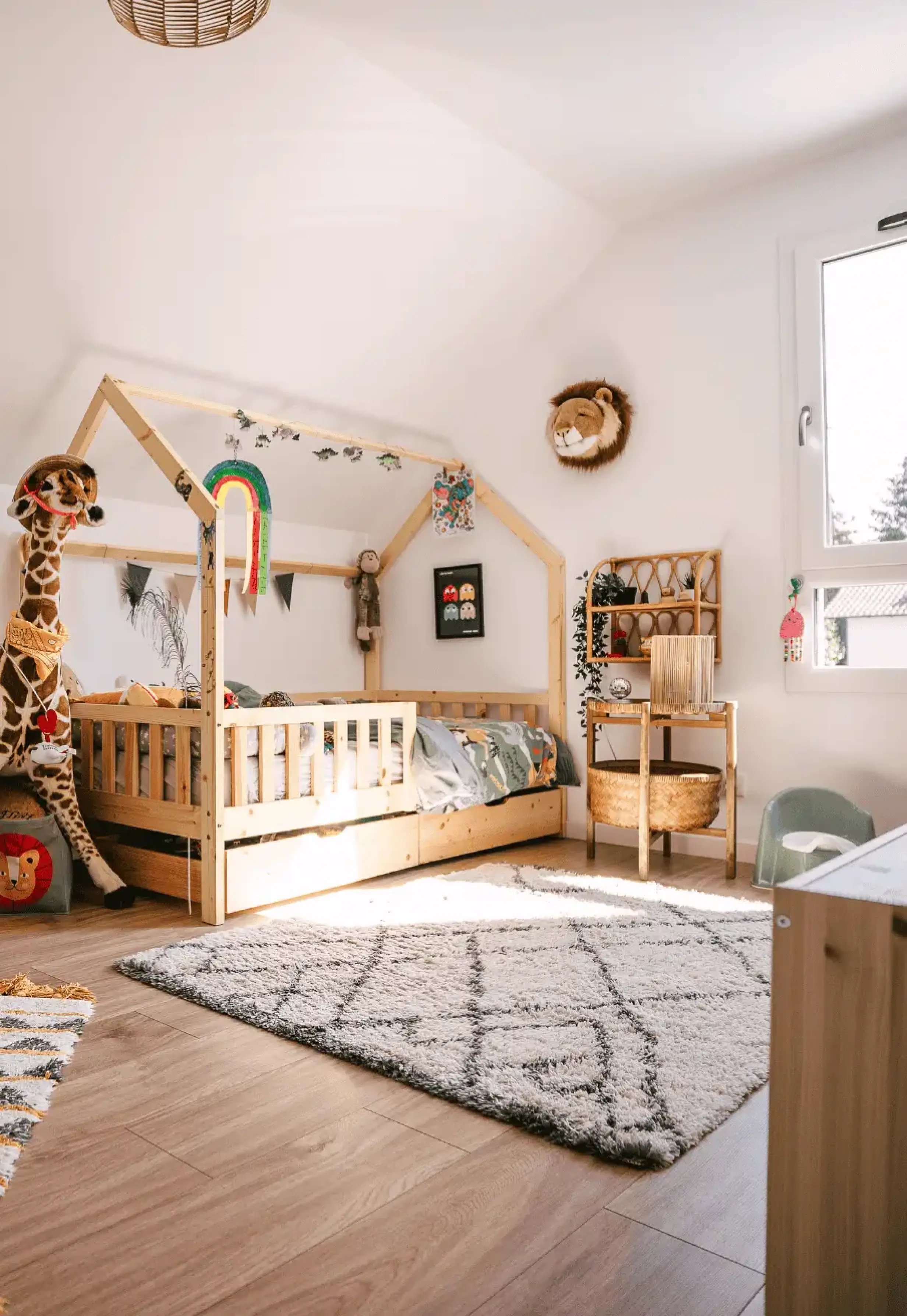 Chambre d’enfant avec lit cabane en bois, décoration douce et lumière naturelle.