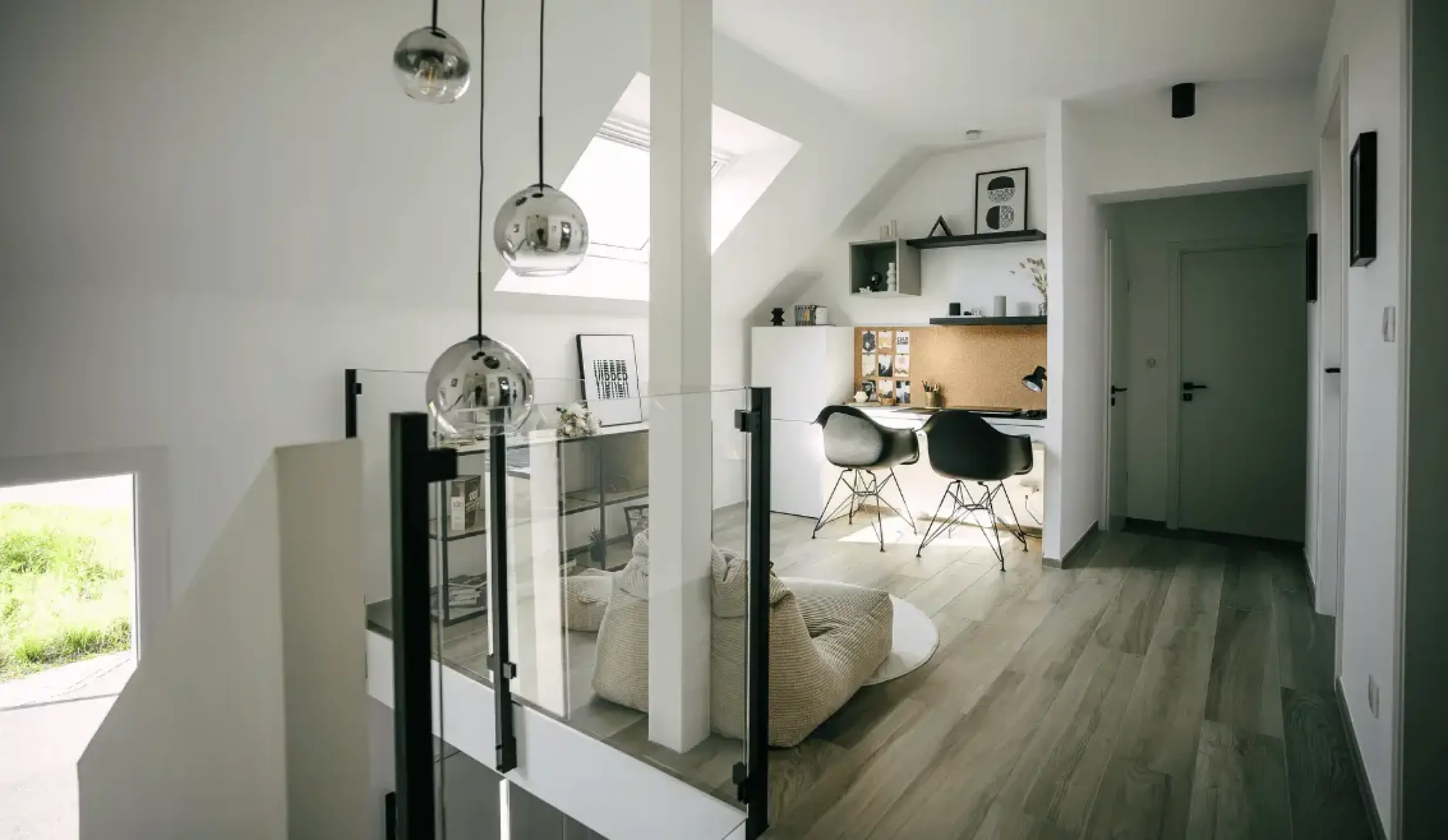 Bureau aménagé sous combles avec deux postes de travail, rangements muraux et coin détente.