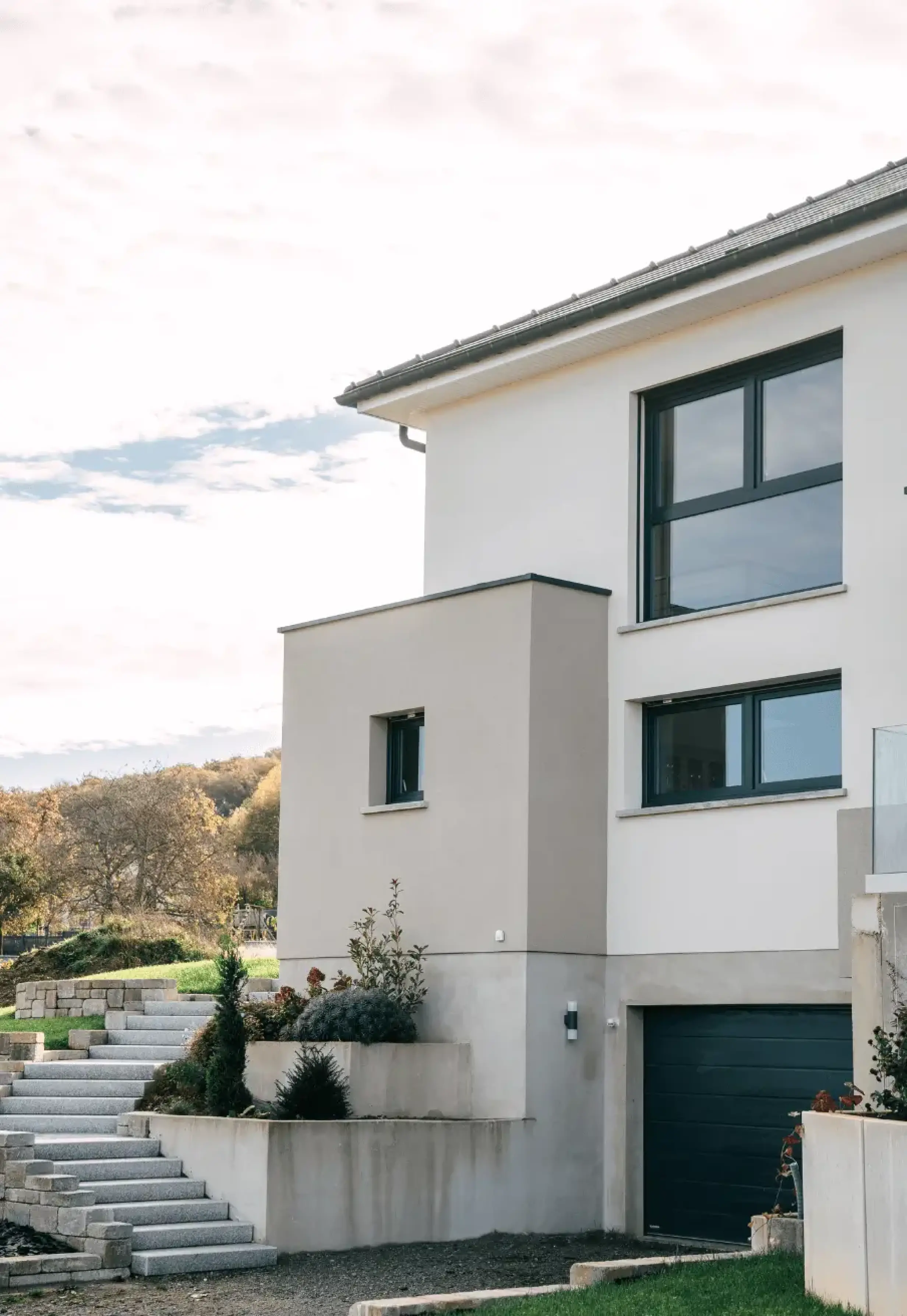 Architecture extérieure d’une maison contemporaine avec grandes ouvertures et façade sobre.