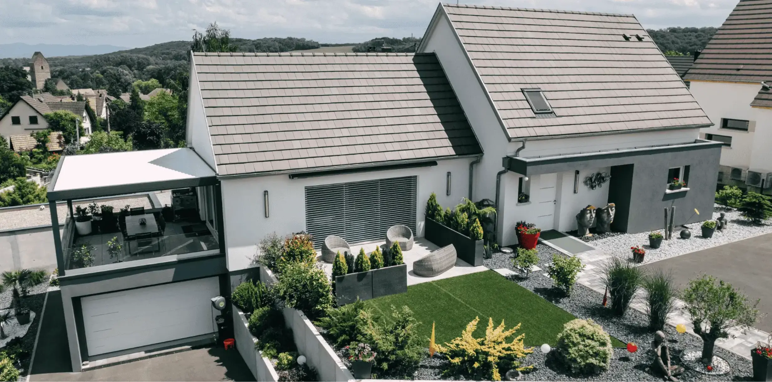 Maison moderne à étage avec garage, toiture à deux pans et jardin paysager