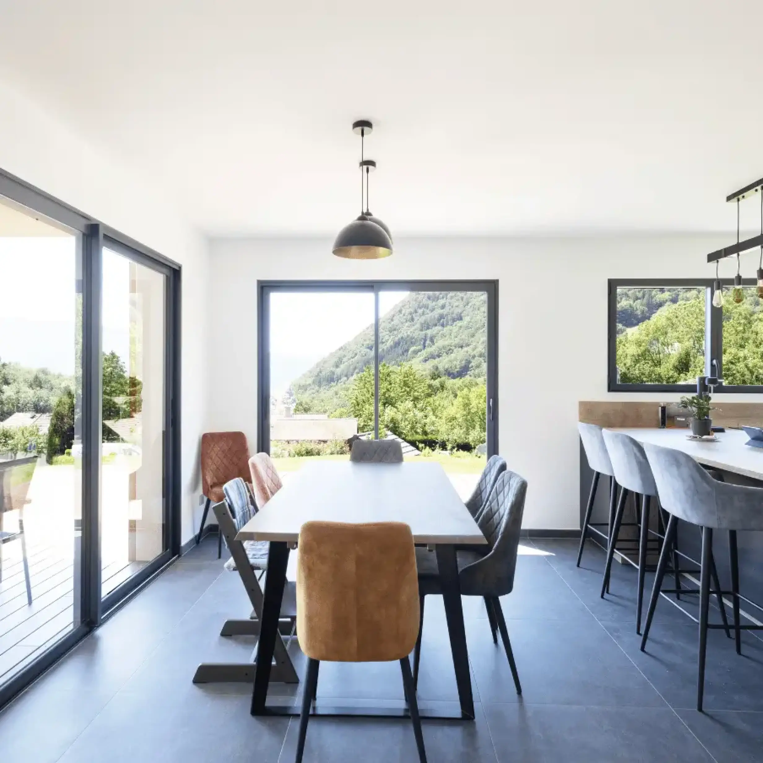 Salle à manger moderne avec baies vitrées et vue sur les montagnes