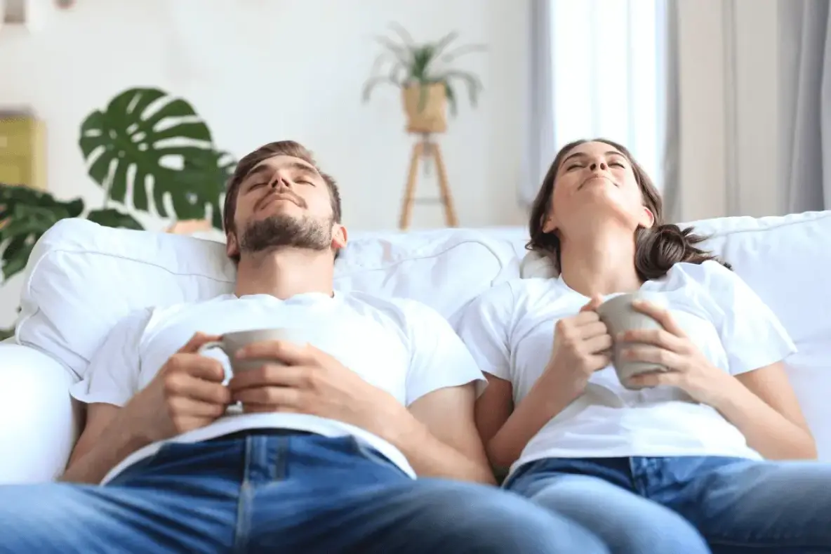 Couple détendu savourant un moment de bien-être dans leur maison neuve en Alsace.